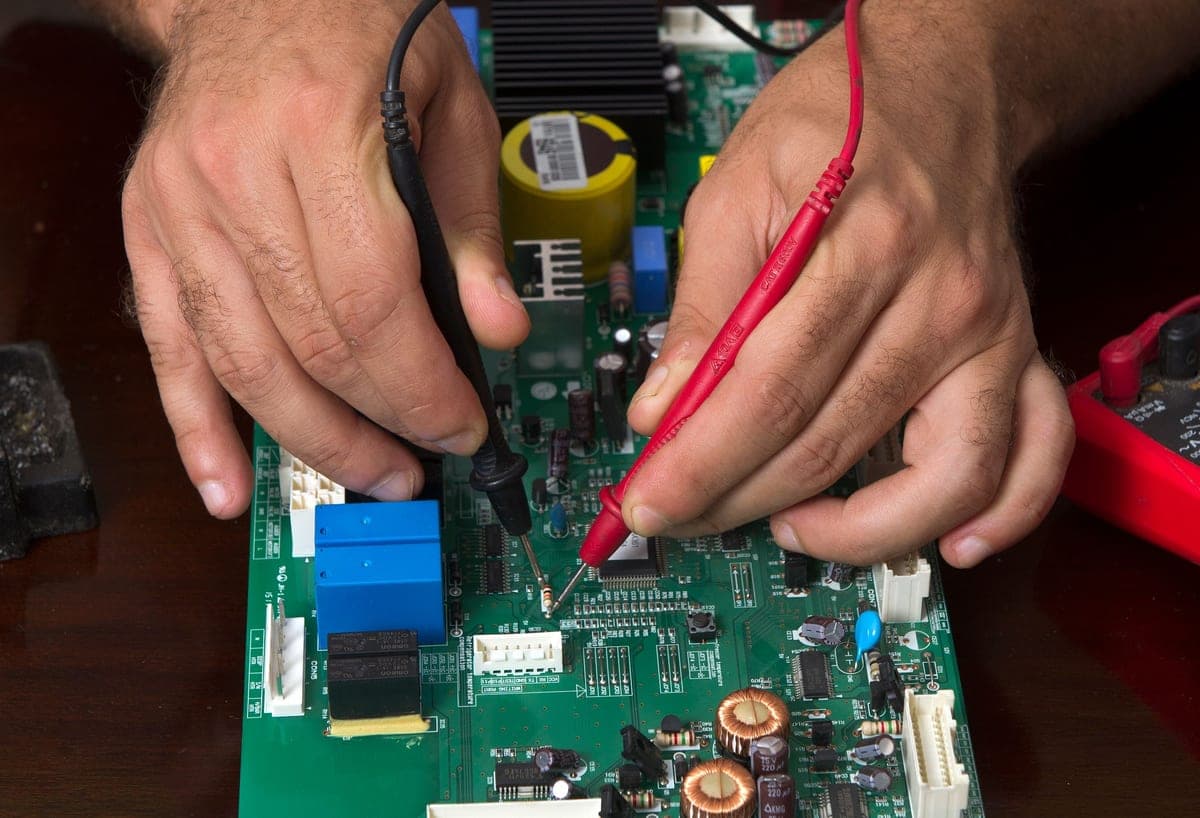 Hands examining audio equipment on a workbench