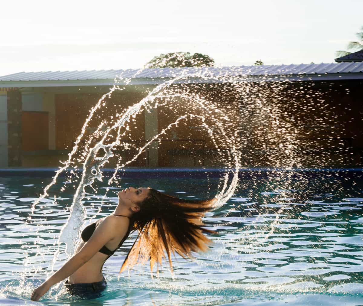 Water splashing in bright sunlight beside a swimming pool