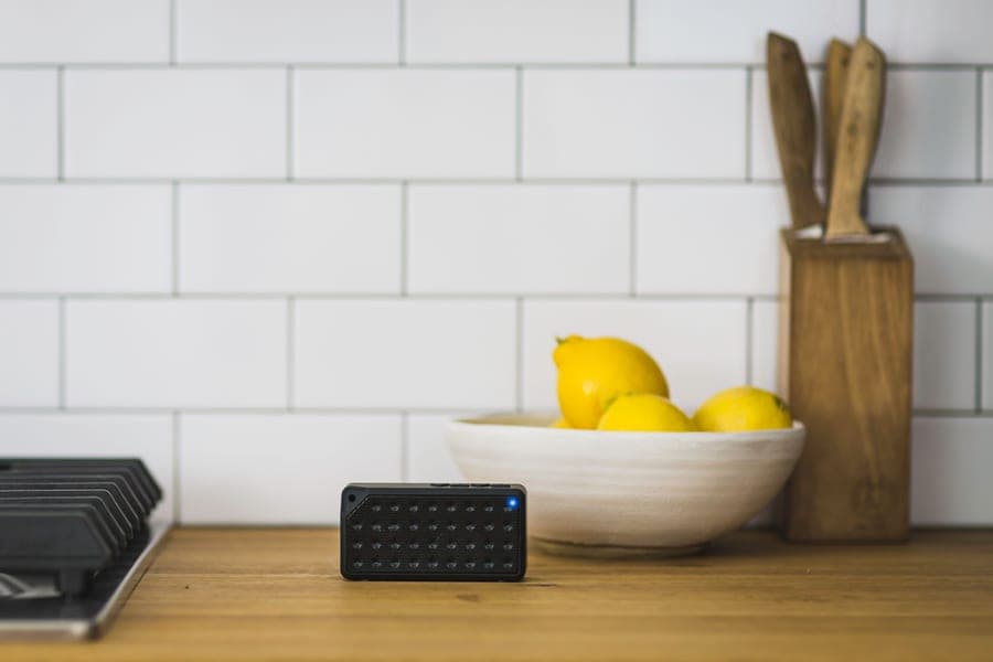 A slim rectangular Bluetooth speaker on a kitchen counter