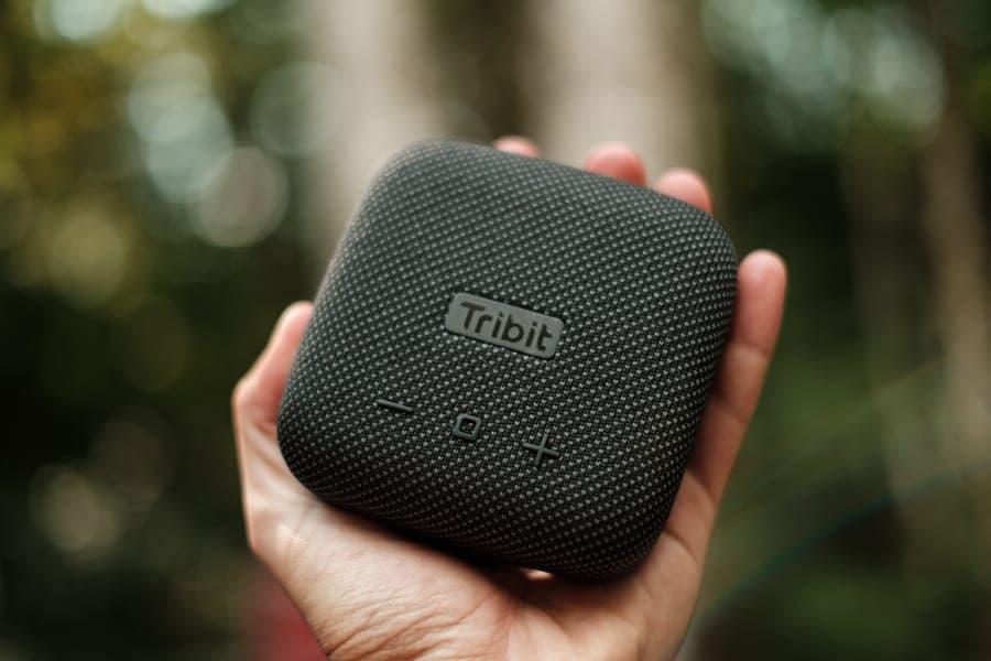 A pocket-sized Bluetooth speaker held in one hand