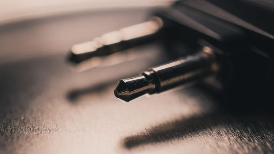Macro close-up of a metallic audio jack on a brushed metal surface
