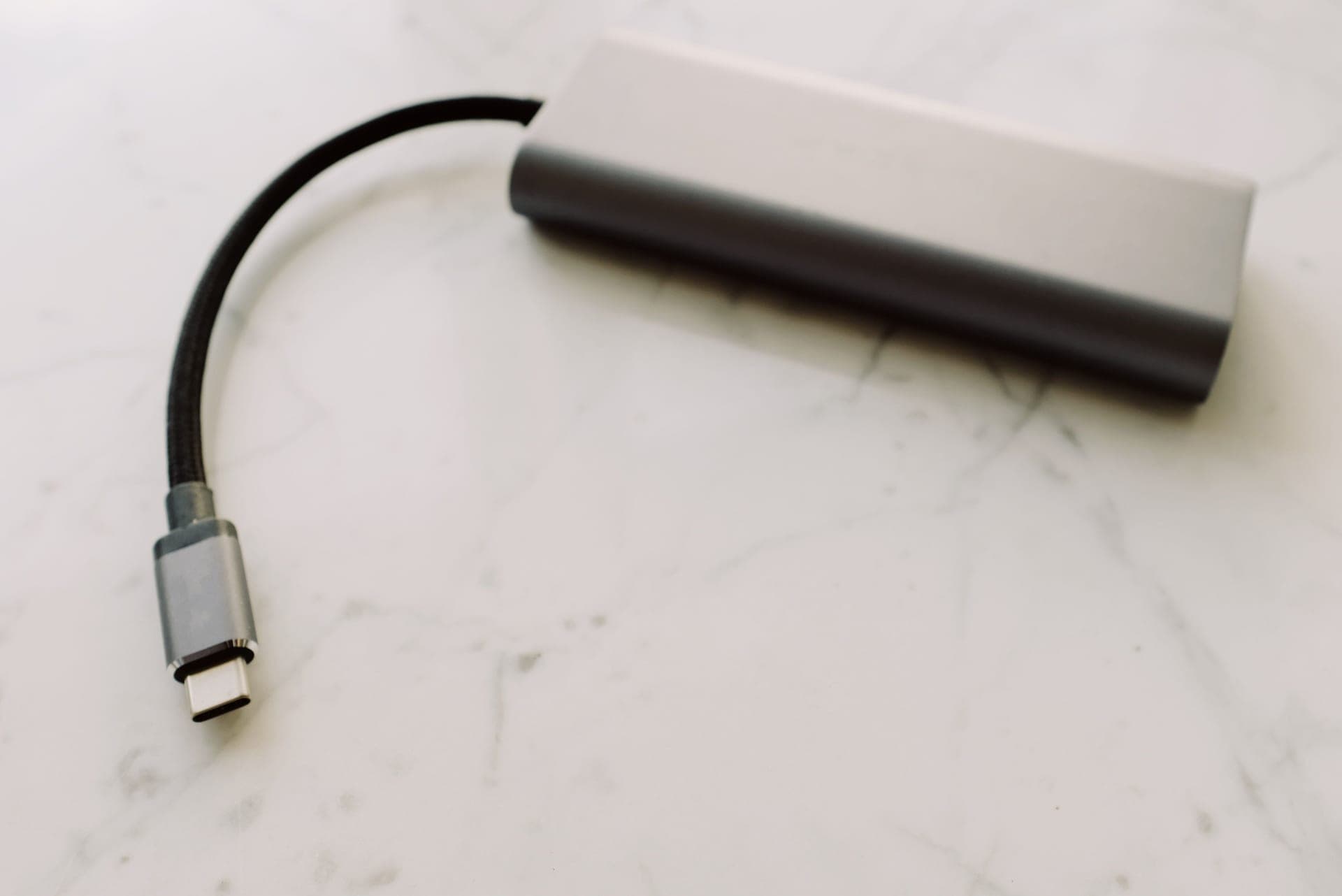 A close-up of a USB-C charging adapter on a stone surface