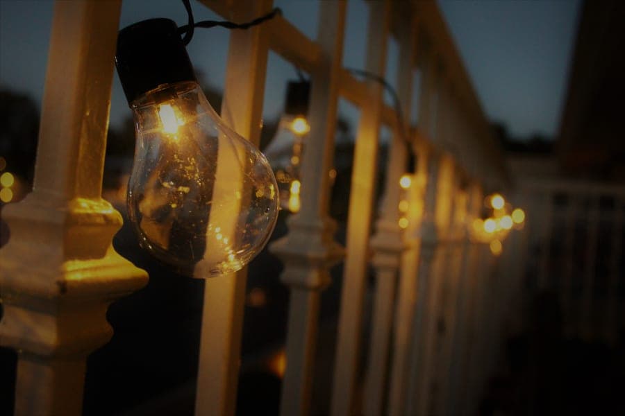 Warm string lights glowing over a patio in the evening