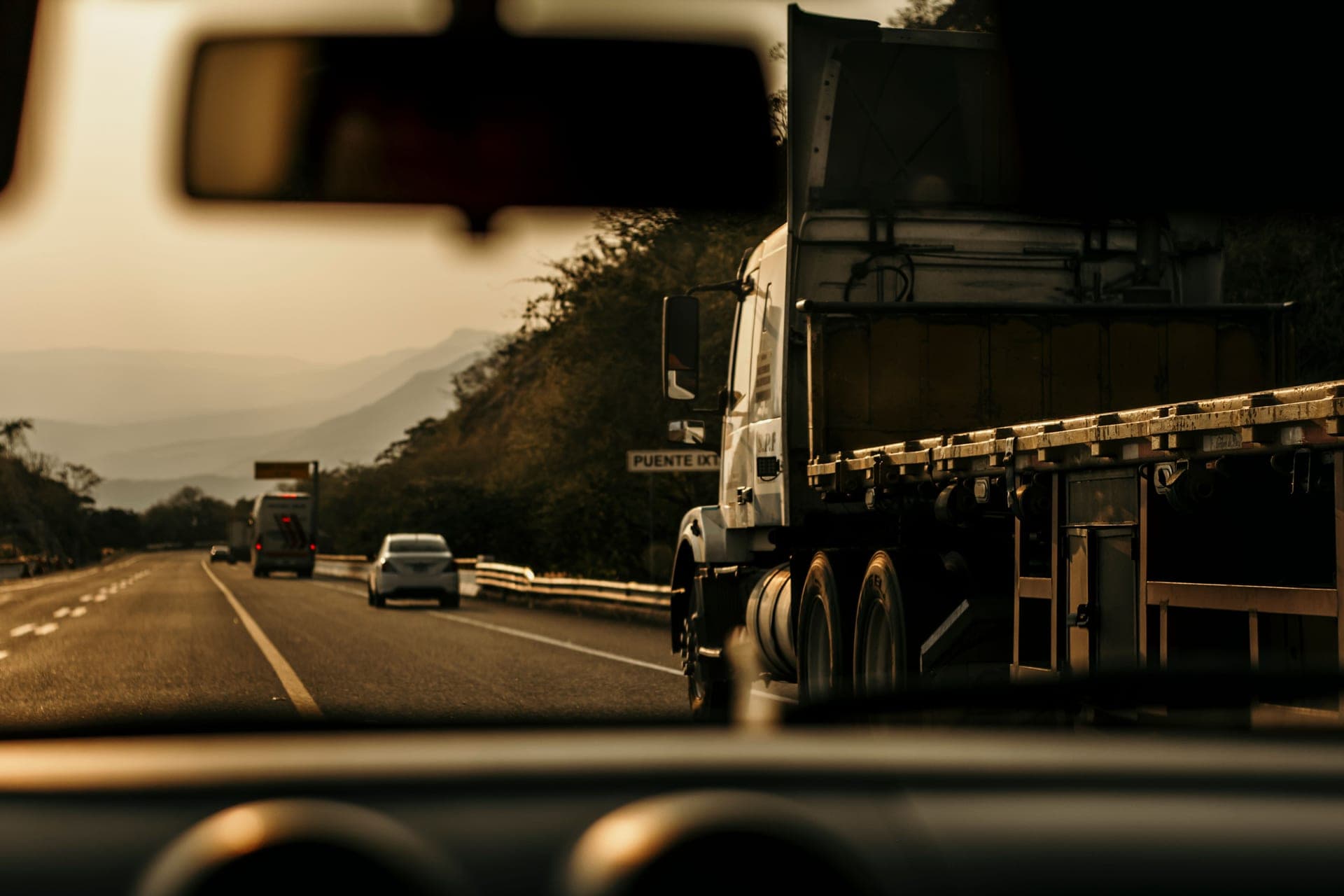 A cargo truck on a highway at sunset